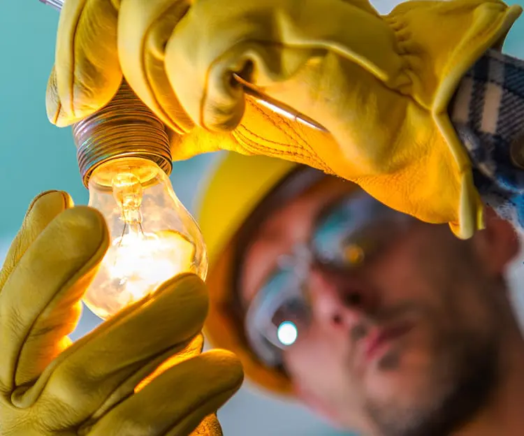 Electrician inspecting lightbulb