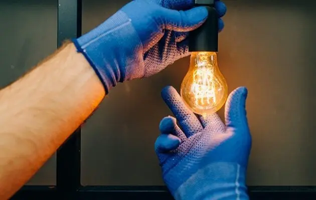 Electrician screwing in a lighbulb