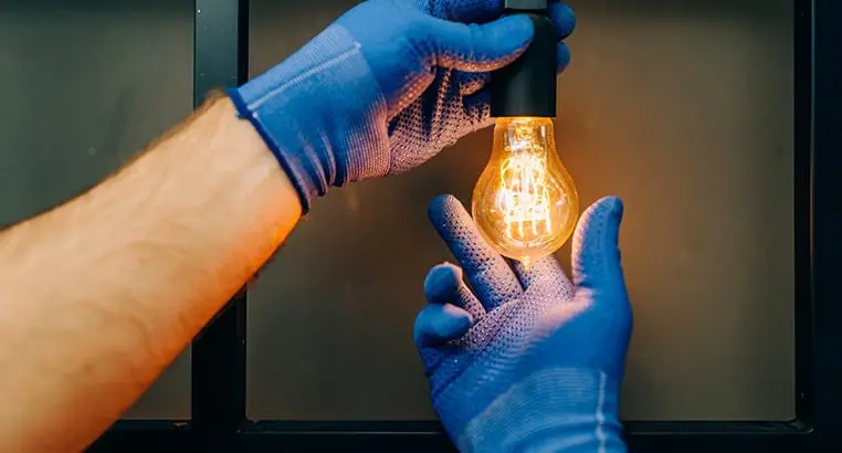 Electrician screwing in a lighbulb